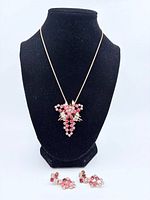 Necklace displayed on bust with pendant and earrings below