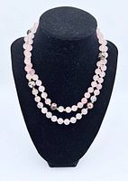 Full view of rose quartz beaded necklace on display bust