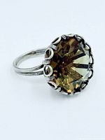 Angled view of ring showing oval faceted smoky quartz and sterling silver mount