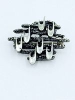 Front view of sterling silver brutalist pin showing design details and clasp