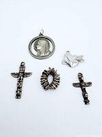 Front view of all five silver charms on white background