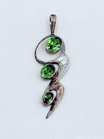 Front view showing three green peridot stones in sterling silver abstract pendant
