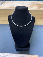 Necklace on display bust showing overall shape and flat omega style