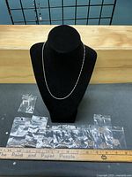 Bust displaying one chain with bagged chains beneath