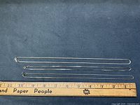 Three sterling silver box chains aligned beside ruler showing lengths