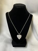 Necklace displayed on stand showing chain length and locket