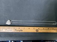 Full view of chain with locket alongside ruler showing length