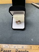 Ring in presentation box showing crossover design and amber stones