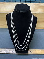 Six sterling silver snake chains displayed on bust to show drape