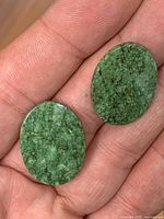 Front view of both jadeite cabochons on hand