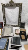 Group view showing large ornate metal frame and several smaller frames