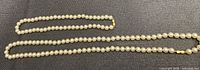 Two pearl strands laid flat showing full length and clasps