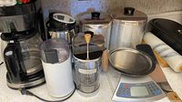 Overall view showing coffee maker, grinder, French press, canisters, pitchers, scale