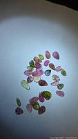 Group of multicoloured leaf-cut tourmaline stones on white background