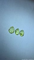 Three lemon-lime tourmalines on white background