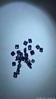 Group of square-cut blue sapphires under spotlight