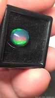 Front view of opal in case showing color play