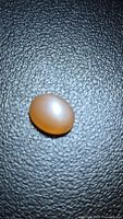 Front view of peach moonstone cabochon showing color and surface