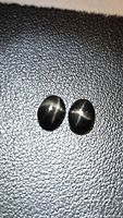 Pair of oval black star diopside cabochons showing star effect