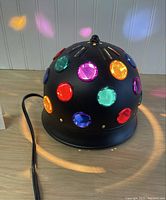 Overall view of black dome light with colored lenses, cord visible