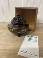 Incense burner with lid on beside wood box