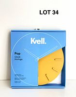 Front of boxed Kvell Pop mustard yellow wall clock showing clock face and branding