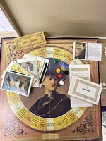 Unfolded game board with cards, money, dice, pawns, markers displayed