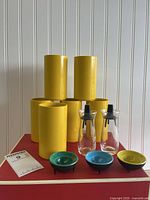 Front view six yellow glasses, two shakers, three egg cups