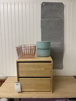 Wooden two-drawer box, grey felt organizer, rose-gold basket, pale blue cement containers stacked displayed