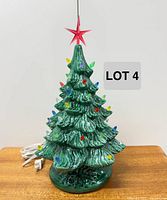 Full view of ceramic Christmas tree on base with cord and pegs visible