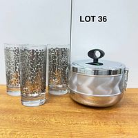 Ice bucket with lid and three leopard print glasses front view