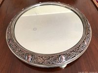 Full view of round gilt brass mirrored plateau on three feet