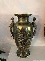 Full view of metal vase showing handles and decoration