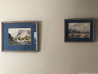 Both framed watercolor paintings hanging on wall