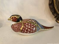Left side profile of Imari pheasant paperweight showing color pattern and shape
