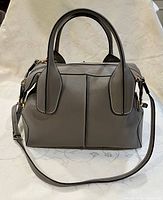 Front view of taupe leather Tod's handbag with handles and strap