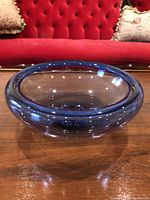 Side view of blue-purple glass bowl on wood surface