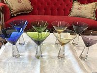 Eight coloured martini glasses front view on white cloth