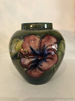 Front view showing pink hibiscus on green glaze