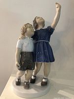 Front view of figurine showing boy and girl looking up