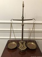 Full view of brass balance scale with two hanging pans