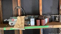 Both belt sanders, dust bag and sanding belts on shelf