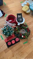 Group shot of all items on floor: ceramic tree, wreath, baskets, candles, tray, knife set, dish