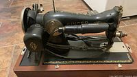 Side view of Singer sewing machine on wooden base showing motor, wiring and decals