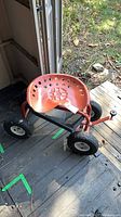 Full view of rolling garden cart showing seat, wheels and frame