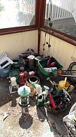 Overall lot with spreaders, watering cans, lanterns, tool caddy and decor