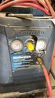 Front of Mastercraft compressor showing gauges, regulator, cracked label