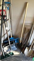 Group of yard tools showing snow shovels, roof rake head, garden rake and other tools