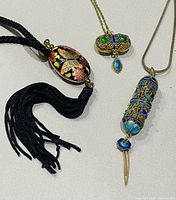 Three necklaces laid out showing pendant shapes and chains