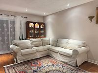 Full view of off-white IKEA Ektorp sectional against wall